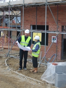Image of two surveyors looking at plan